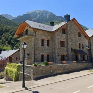 a large stone building with a street light in front of it at El Descanso del Sol - Apartamento en Pirineos in Plan