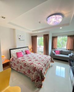 a bedroom with a large bed with pink pillows at Beach 7 Condo, Pattaya in Jomtien Beach