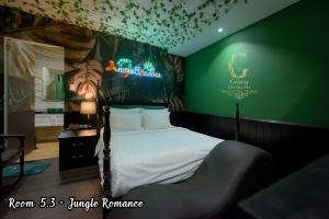 ein Schlafzimmer mit einem Bett mit einer grünen Wand in der Unterkunft Galaxy Hotel 2 in Ho-Chi-Minh-Stadt