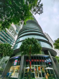 um edifício alto com uma palmeira em frente em Vortex Suites KLCC By Welt em Kuala Lumpur