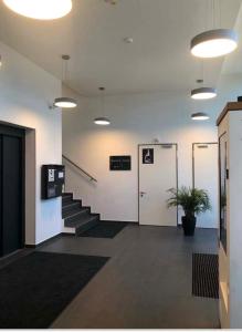 eine Bürolobby mit einer Treppe und einer weißen Tür in der Unterkunft Myroom Business Apartment Nähe Messe München in München