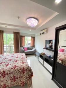 喬木提恩海灘的住宿－Beach 7 Condo, Pattaya，一间卧室配有一张床、一台电视和一张沙发