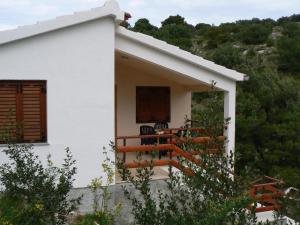 a white house with a balcony with a table at Holiday home Marina in Sali