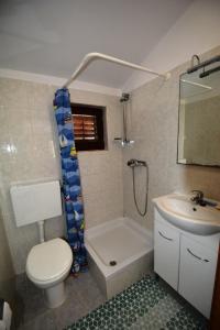 a bathroom with a toilet and a tub and a sink at Holiday home Marina in Sali