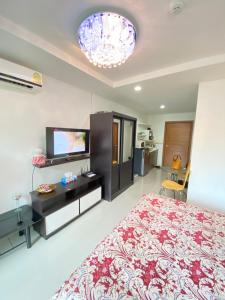 Un dormitorio con una cama y un televisor de pantalla plana. en Beach 7 Condo, Pattaya, en Jomtien Beach