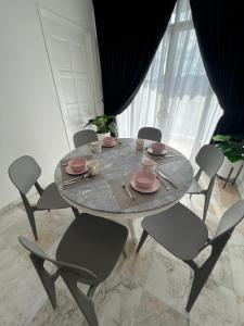 una mesa y sillas con platos y platos. en Luï Luï Comfy Condo in Great Location en Kuah