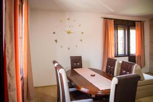 een eettafel en stoelen met een klok aan de muur bij Beli Ocnjak in Soko Banja +8 foto's