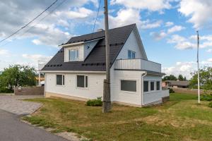 a white house with a black roof at Relax Interior Stylish House in Rakvere in Rakvere
