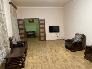 a living room with two chairs and a flat screen tv at House 56 in Yerevan