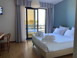 a bedroom with a bed with towels on it at Alevic Hotel Sirmione in Sirmione