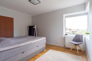 um quarto com uma cama, uma cadeira e uma janela em Relax Interior Stylish House in Rakvere em Rakvere