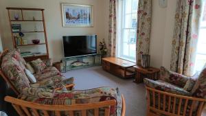 a living room with a couch and a television at Island View in Lymington