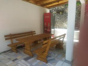 a wooden table and benches sitting next to a window at Vila Nomada in Blagaj