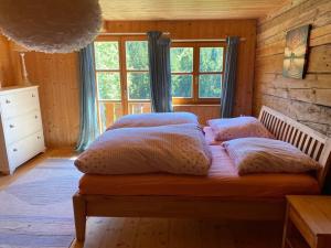 1 dormitorio con cama con almohadas y ventana en Ferienhaus Klause en Neureichenau