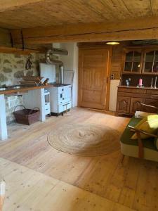 a living room with a wooden floor and a kitchen at Ferienhaus Klause in Neureichenau