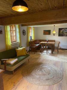 Ferienhaus Klause في نويغايشيناو: غرفة معيشة مع أريكة خضراء وطاولة