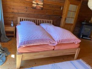 Ferienhaus Klause في نويغايشيناو: سرير عليه وسادتين في غرفة