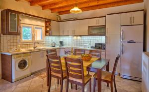 a kitchen with a table and chairs and a refrigerator at Drosia Beach House Almyros Corfu in Almiros Beach