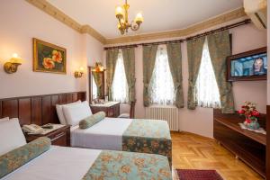 ein Hotelzimmer mit 2 Betten und einem TV in der Unterkunft Osmanhan Hotel in Istanbul