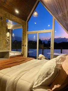 a bedroom with a large bed with a large window at Recanto Entre Rios in Bom Jardim da Serra +24 photos