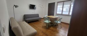 uma sala de estar com um sofá, uma mesa e uma cadeira em A casa di Pintus em Villasimius
