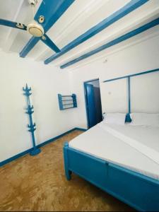ein Schlafzimmer mit einem blauen und weißen Bett in einem Zimmer in der Unterkunft Beach House Paje in Paje
