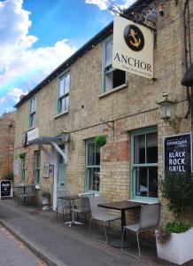 a brick building with a table and chairs outside at Little Downham Anchor in Ely