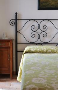 cama con marco negro y edredón verde en Hotel Giardino Giamperduto, en Bernalda