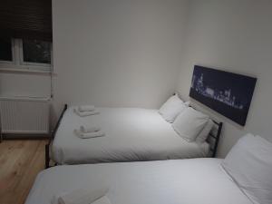 a room with two beds and a tv on the wall at City Sparrow Apartments 6 in London