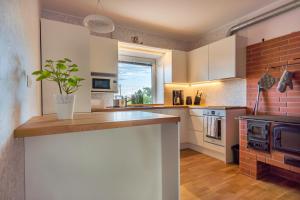 a kitchen with white cabinets and a brick wall at Relax Interior Stylish House in Rakvere in Rakvere