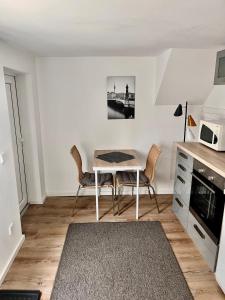 eine Küche mit einem Tisch und Stühlen im Zimmer in der Unterkunft Gästezimmer Teltow in Teltow