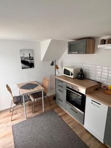 eine kleine Küche mit einem Tisch und einer Mikrowelle in der Unterkunft Gästezimmer Teltow in Teltow