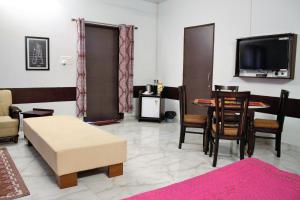 - un salon avec une télévision, une table et des chaises dans l'établissement Shivir Aranya - Wilderness Resort, à Alwar