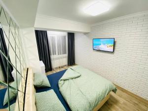 1 dormitorio con 1 cama y TV en la pared en Central Eco View Apartment, en Chişinău