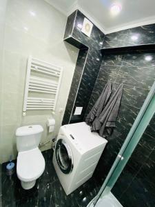 y baño con aseo y lavadora. en Central Eco View Apartment, en Chişinău