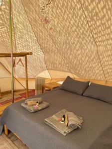 a bed in a tent with towels on it at Paraiso Bell Tent in Tortosa