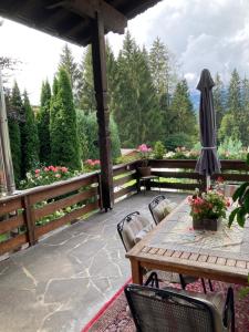 eine Terrasse mit einem Tisch, Stühlen und einem Sonnenschirm in der Unterkunft Ferienhaus Wieswald in Ehrwald