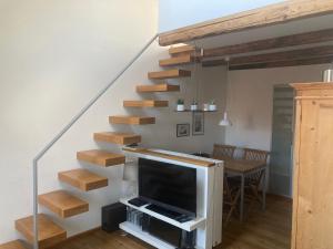 ein Wohnzimmer mit einer Treppe und einem TV in der Unterkunft Ferienwohnung Lindenstraße in Hasselfelde