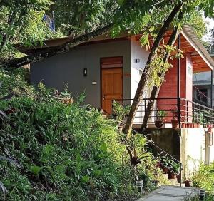 una piccola casa con una porta in legno su una collina di The Little Paradise a Kalimpong
