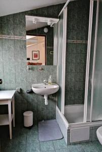 a bathroom with a sink and a shower and a mirror at RETRO Apartments in Bjelovar