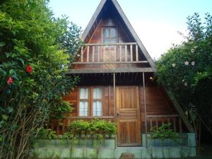 una pequeña casa de madera con una puerta grande en Chalès em Ilhabela Litoral Norte en Ilhabela