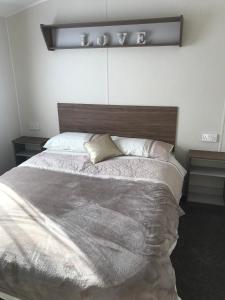 a bedroom with a large bed with a wooden headboard at Crimdon dene holiday park in Hartlepool