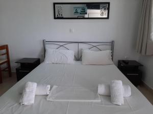a white bed with two white towels on it at Apartment in Mpenitses with Sea Views & Pool in Benitses
