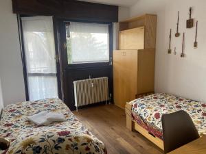 een kleine kamer met 2 bedden en een raam bij Enjoy Sauze d'Oulx in Sauze dʼOulx