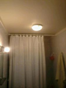 a bathroom with a shower curtain and a light at Residencia "Libertad" in San Andrés