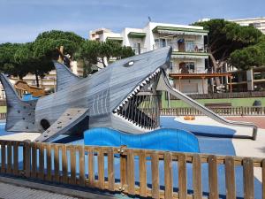a playground with a shark shaped slide in a park at Apartaments Les Roques in Platja d'Aro