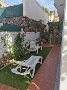 eine Terrasse mit 2 Liegestühlen und einem Tisch in der Unterkunft jardin44 in Santa Úrsula