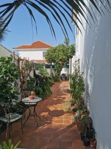 einen Innenhof mit einem Tisch, Stühlen und Pflanzen in der Unterkunft jardin44 in Santa Úrsula