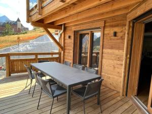 a table and chairs on the deck of a cabin at Chalet Neuf du Pape in Les Deux Alpes