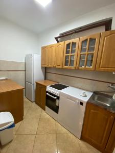 a kitchen with wooden cabinets and a white stove top oven at Apartmani Mustur in Bijela